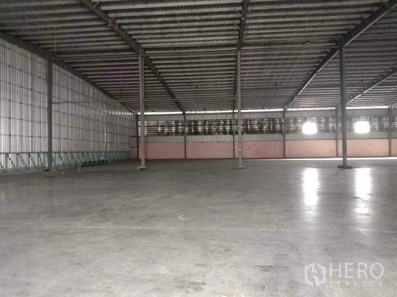 Factory for rent in Ban Phaeo, Samut Sakhon - Expansive production hall with polished concrete slab, columns and ventilation panels.