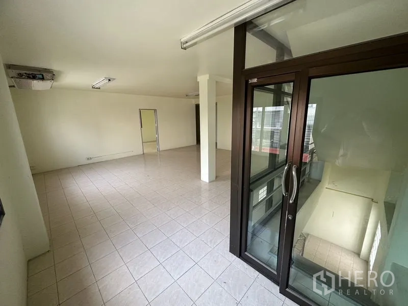 Factory for rent in Bang Bua Thong, Nonthaburi - Office space with a glass door opening to the stairwell.