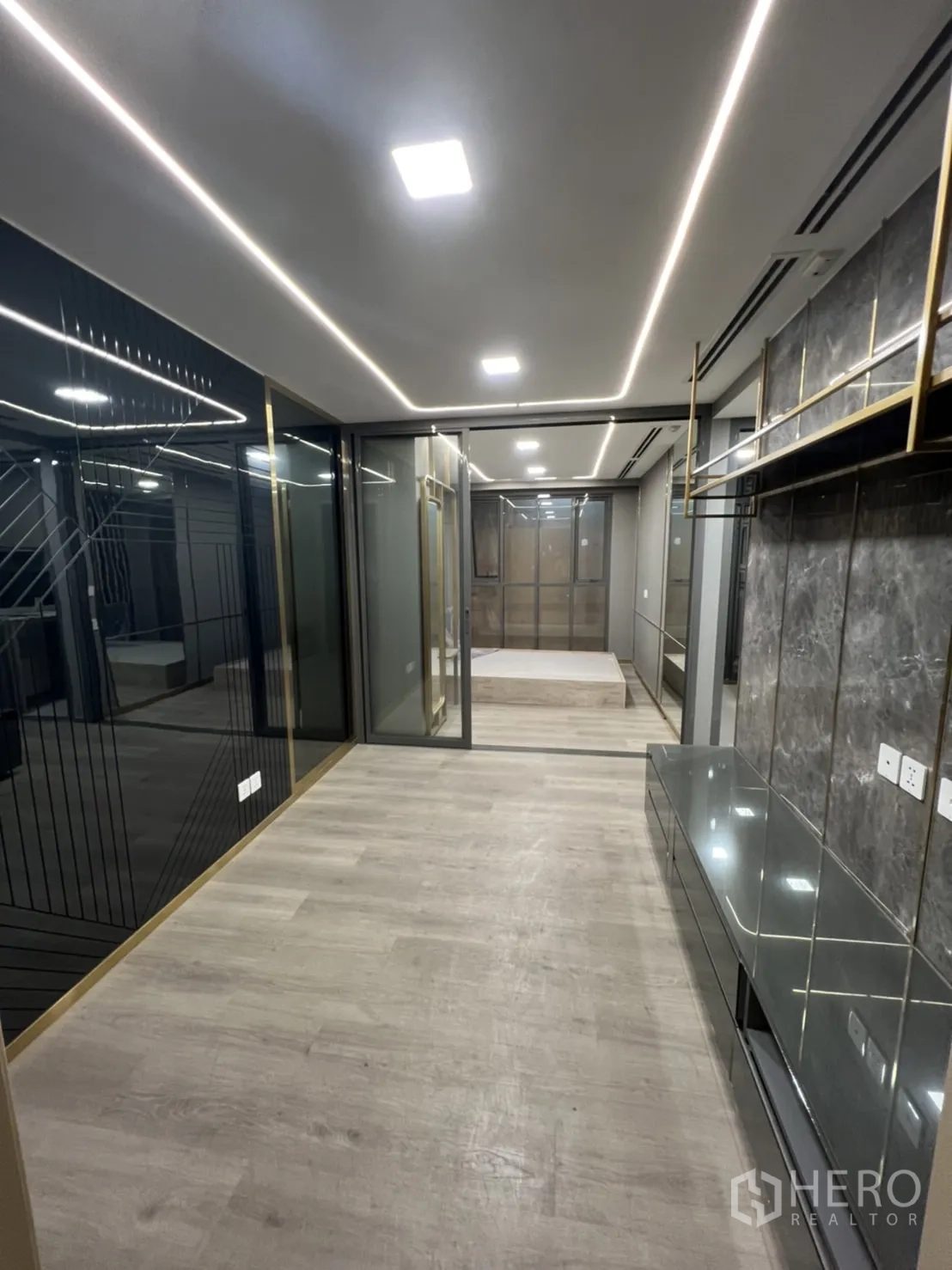 Shophouse for rent in Phra Khanong, Bangkok - Upper floor office area with linear LED lighting, glass partitions and wood‑look flooring.