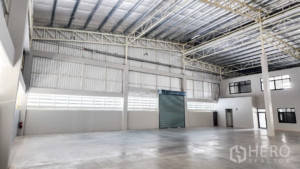 仓库 for rent in Mueang Chon Buri, Chon Buri - 内部视角，卷闸门与相连的办公区一同可见。