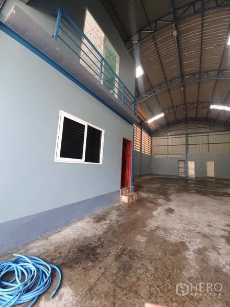 Warehouse for rent or sale in Bang Bua Thong, Nonthaburi - Warehouse interior with mezzanine office, concrete floor, and high curved steel roof.