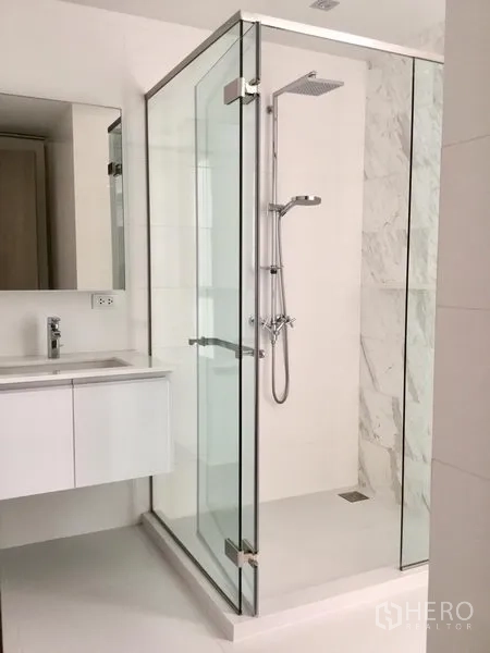 Condominium for rent or sale in Watthana, Bangkok - White bathroom featuring a glass-enclosed rain shower and floating vanity.