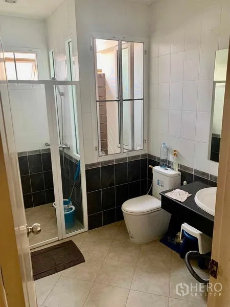 Detached House for rent in Prawet, Bangkok - Bathroom with glass-enclosed shower and black-and-white tiles.