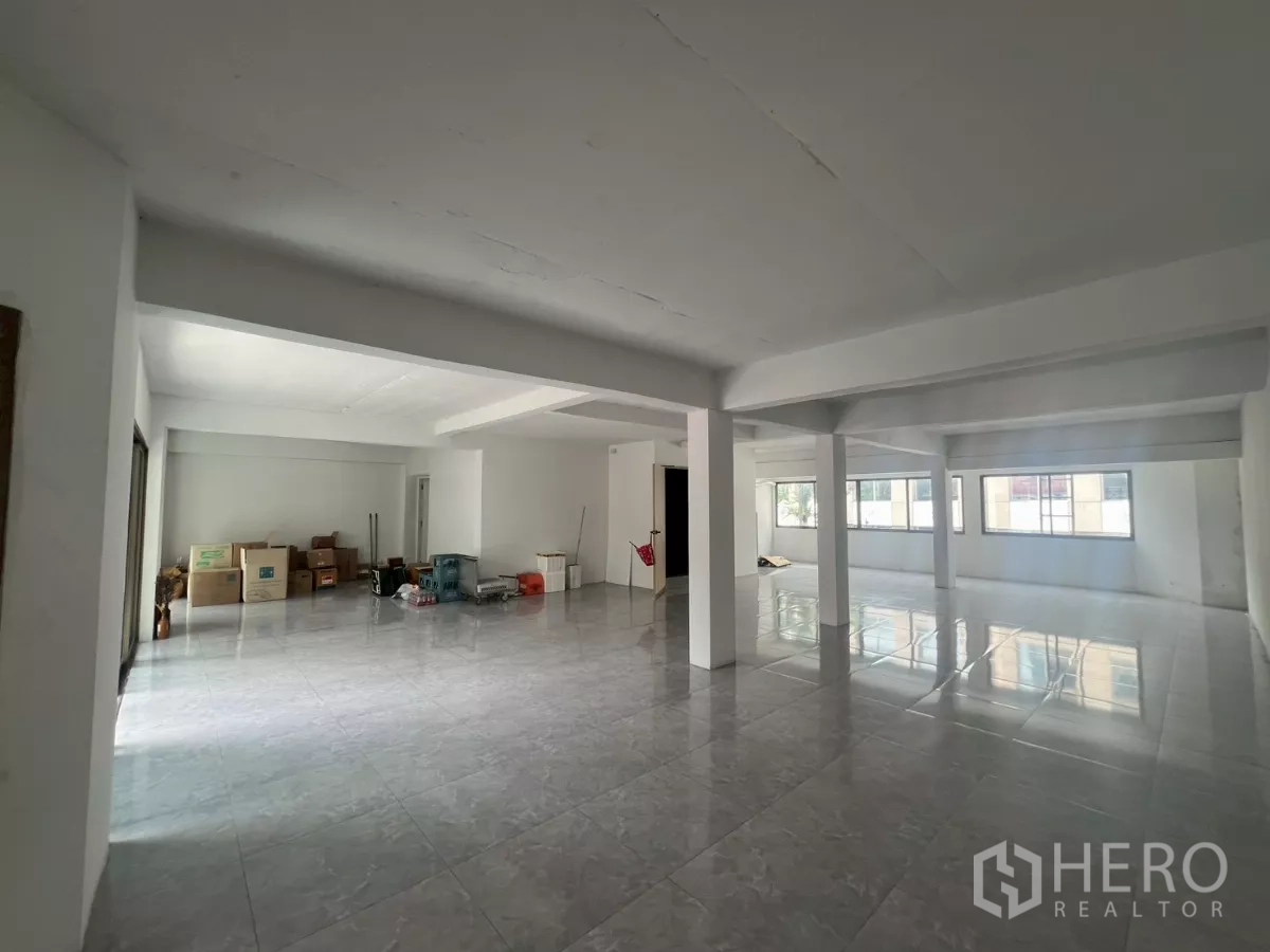 Retail Space for rent in Pathum Wan, Bangkok - Spacious retail floor with multiple windows and some storage boxes along the wall.