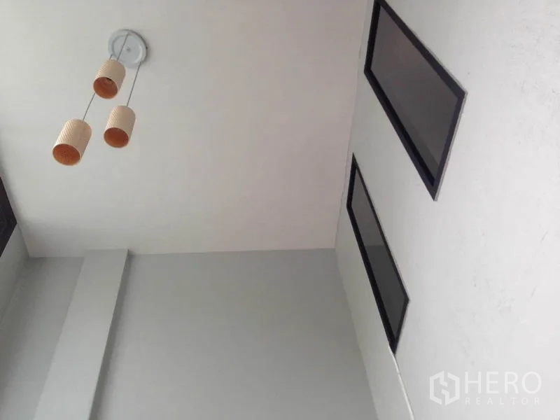 Home Office for rent or sale in Wang Thonglang, Bangkok - Ceiling view showing a modern triple pendant light and high rectangular windows.