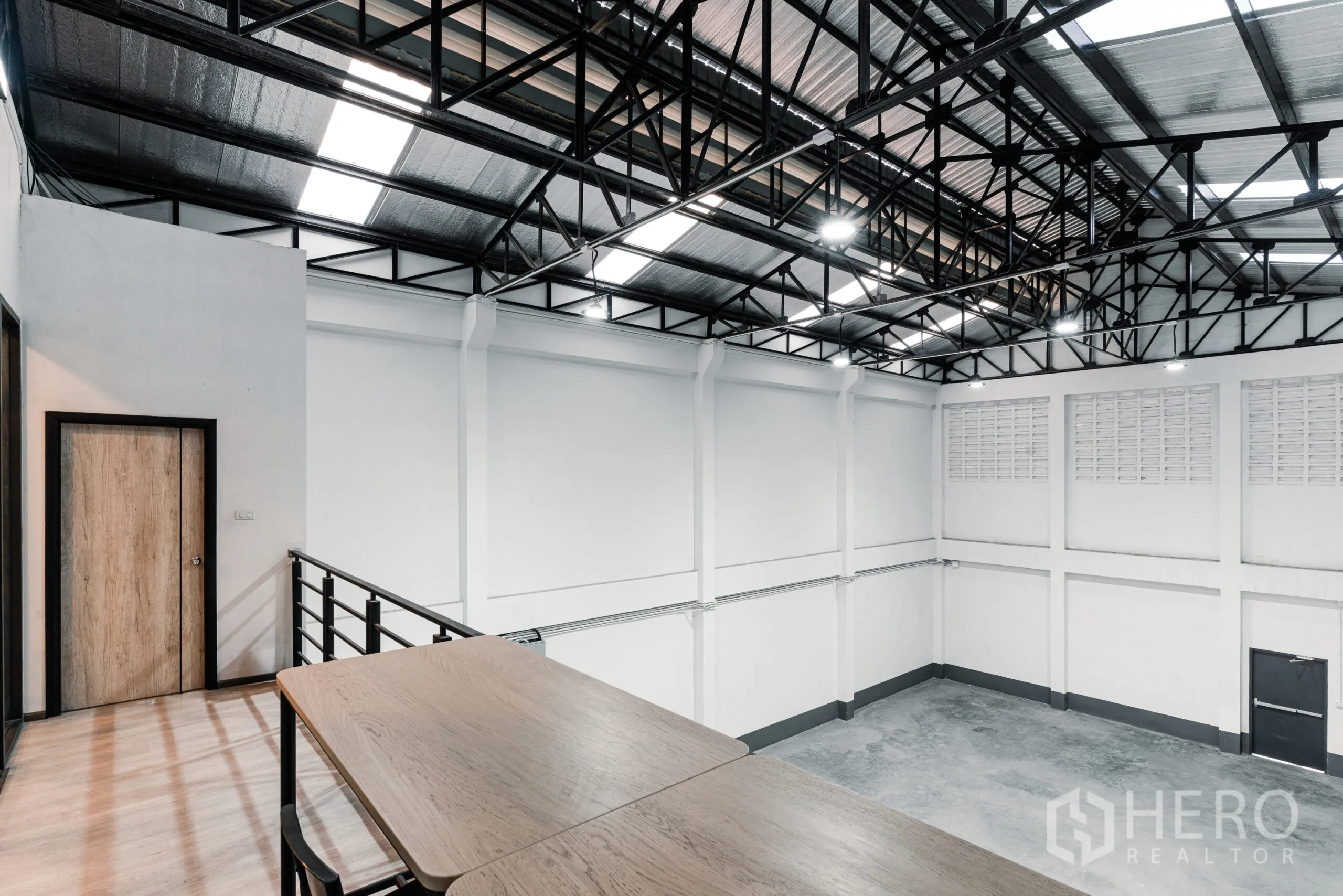 Warehouse for rent in Mueang Samut Sakhon, Samut Sakhon - Mezzanine perspective beside office room showing insulated steel roof, lighting and expansive warehouse below.