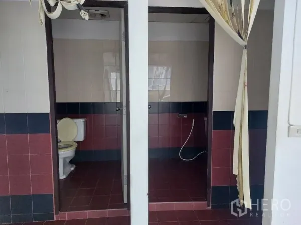 Office Space for rent in Pathum Wan, Bangkok - Private office restrooms with tiled floors, separated stalls, and handheld bidet sprayers.