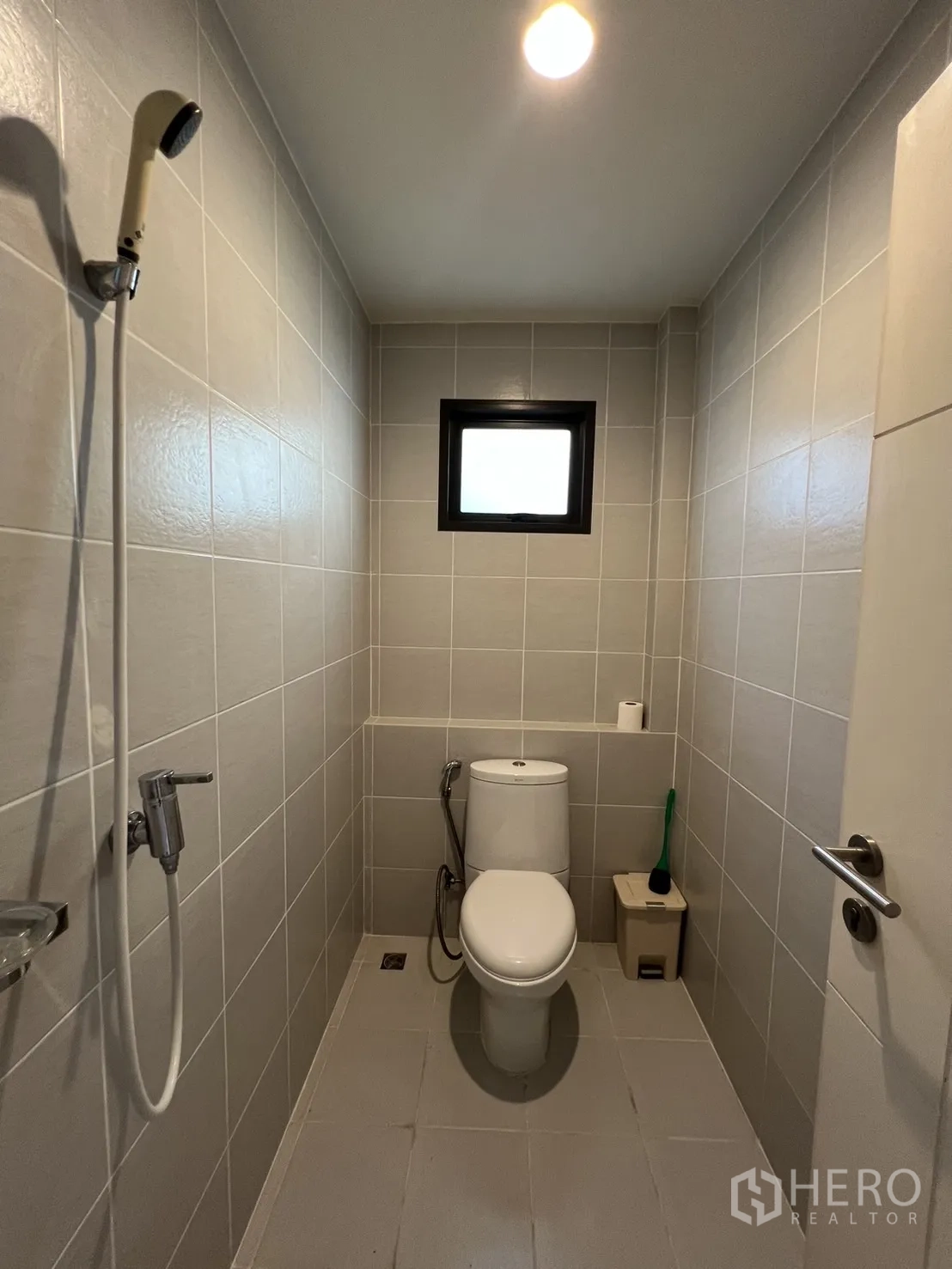 Detached House for rent or sale in Bang Kapi, Bangkok - Narrow bathroom with shower and toilet finished in light tiles.