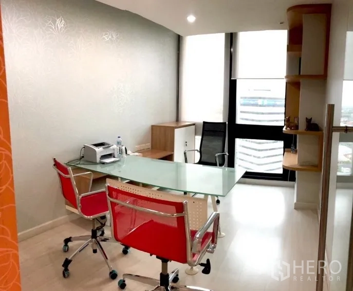 สำนักงาน ให้เช่าในBang Na, Bangkok - ห้องทำงานตกแต่งครบ โต๊ะกระจก เก้าอี้แดง และหน้าต่างสูงมองเห็นวิวเมือง