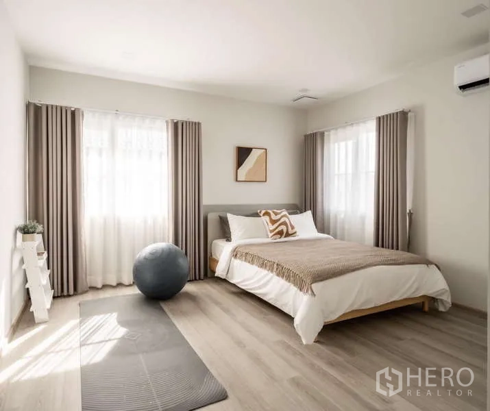 Detached House for rent or sale in Bang Phli, Samut Prakan - Bright bedroom with double bed, yoga mat and exercise ball, soft curtains and wood flooring.