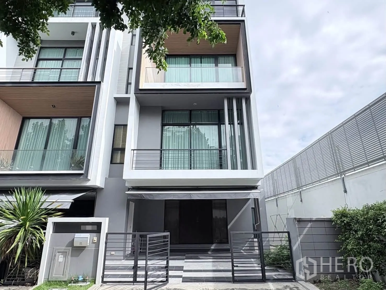 独栋房屋 for rent in Saphan Sung, Bangkok - 现代住宅外立面，设阳台、大窗与带门的庭院车位。