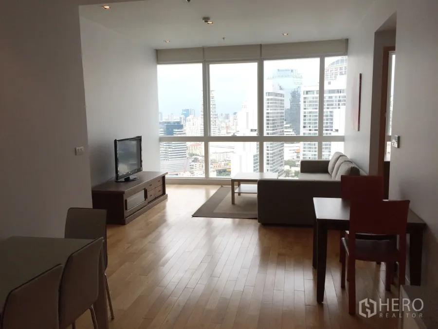Condominium for rent in Khlong Toei, Bangkok - Bright living and dining area with floor-to-ceiling windows and panoramic Bangkok skyline view.