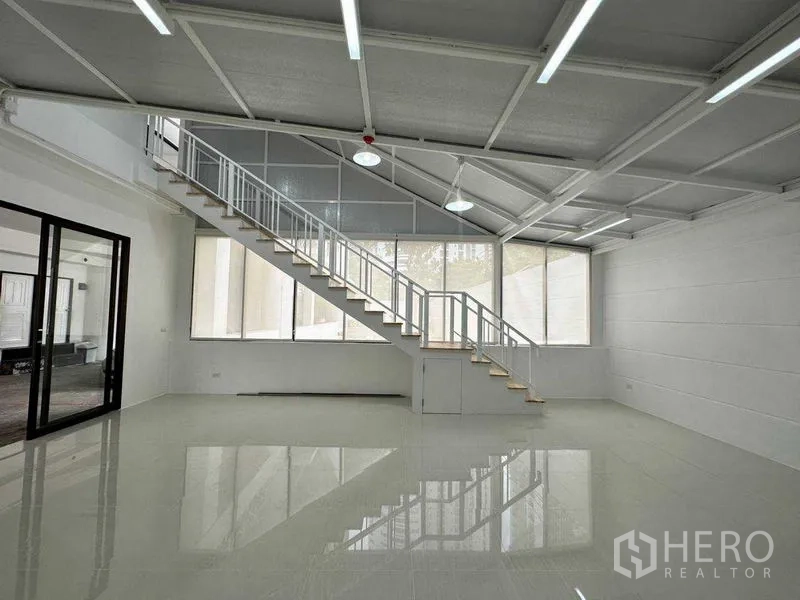 办公空间 出租或出售在Khlong Toei, Bangkok - 明亮开放的办公室，长楼梯、斜顶与大面积窗户。