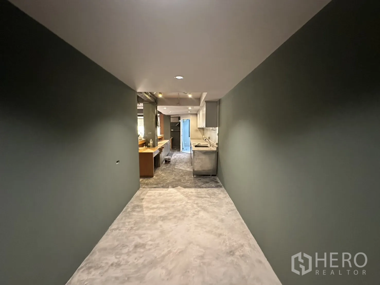 Retail Space for rent in Watthana, Bangkok - Wide corridor with polished concrete floor and green walls leading toward the service area.