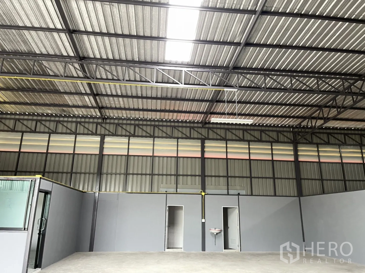 工厂 出租在Khlong Luang, Pathum Thani - 高挑梁架与透光板，上方照明充足，下方设两间卫生间与洗手盆。