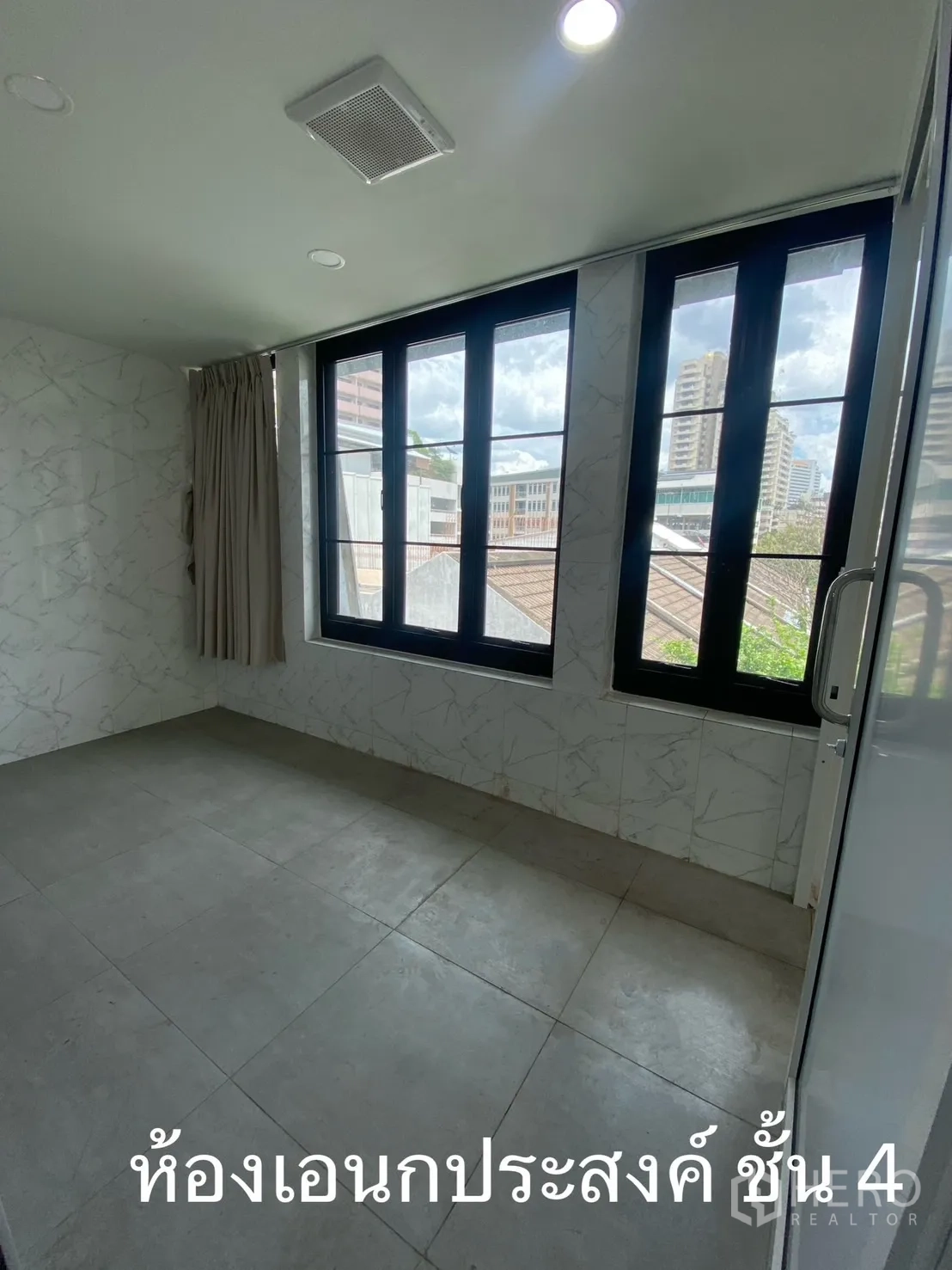 Shophouse for rent in Watthana, Bangkok - Multi-purpose room with grey floor tiles and black-framed windows.