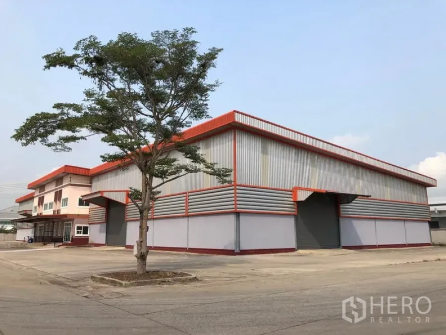 Factory for rent in Bang Len, Nakhon Pathom - Modern steel-clad factory with red trim, wide concrete driveway and loading bays in Bang Len.