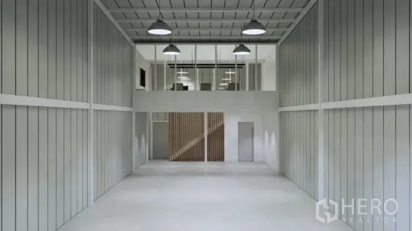 Warehouse for rent in Prawet, Bangkok - Warehouse interior facing mezzanine office with industrial pendant lighting and metal wall panels.