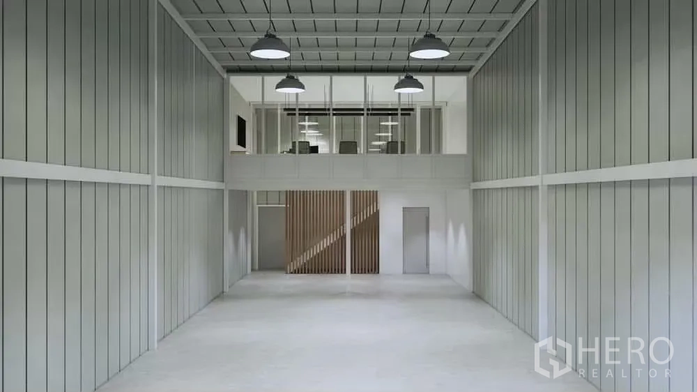 Warehouse for rent in Prawet, Bangkok - Warehouse interior facing mezzanine office with industrial pendant lighting and metal wall panels.