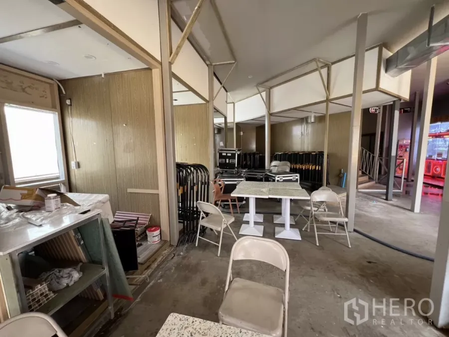Retail Space for rent in Khlong Toei, Bangkok - Partially fitted retail interior with open-plan layout, partition framing, terrazzo tables, folding chairs and concrete flooring.