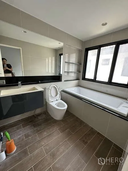 Detached House for sale in Lam Luk Ka, Pathum Thani - Bathroom with bathtub, vanity and window.