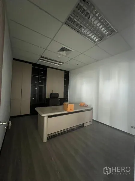 办公空间 出租在Huai Khwang, Bangkok - 行政办公室，现代书桌与储物墙，白墙与网格吊顶。