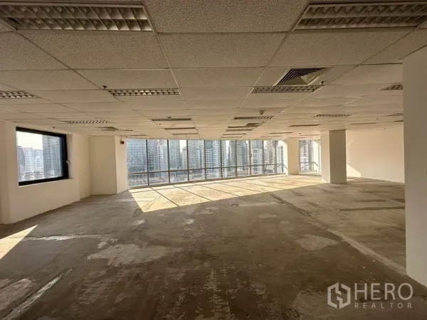 Office Space for rent - Unfurnished office floor plate with natural light across concrete subfloor and panoramic glazing overlooking the city.