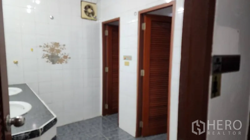 Office Space for rent or sale in Khlong Toei, Bangkok - Restroom area with twin sinks and wooden doors to stalls.