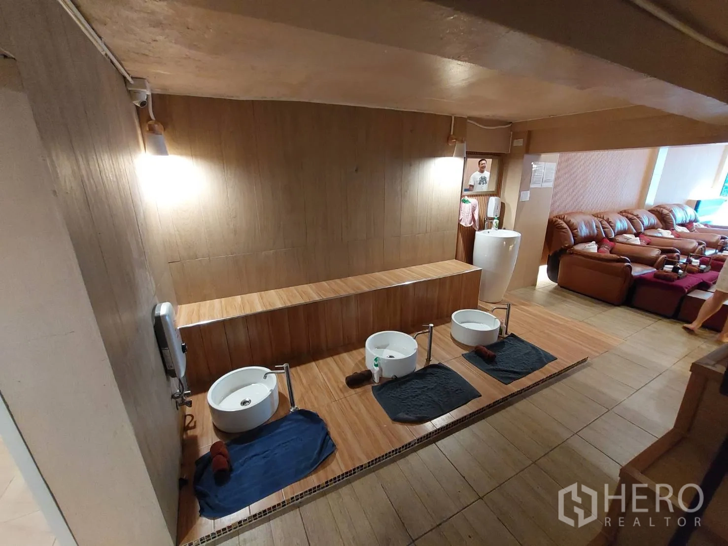 Shophouse for rent or sale in Watthana, Bangkok - Wood‑finished space featuring foot wash stations and lounge seating.