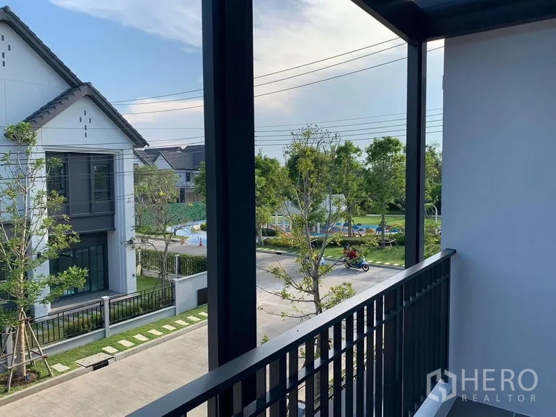 Detached House for rent or sale in Bang Phli, Samut Prakan - Second-floor balcony overlooking a tree-lined street and community park