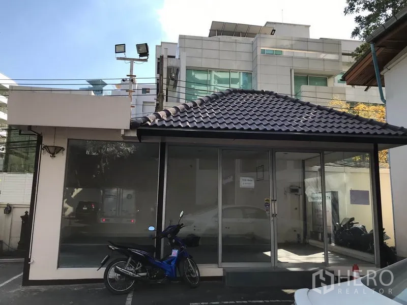 Retail Space for rent in Watthana, Bangkok - Glass-fronted exterior of the retail kiosk with tiled roof and parking bay, showing earlier condition.
