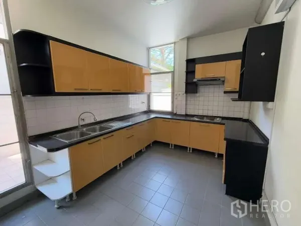 Detached House for rent in Bang Kapi, Bangkok - Light kitchen with L‑shaped cabinetry, double sink, tiled backsplash and range hood.