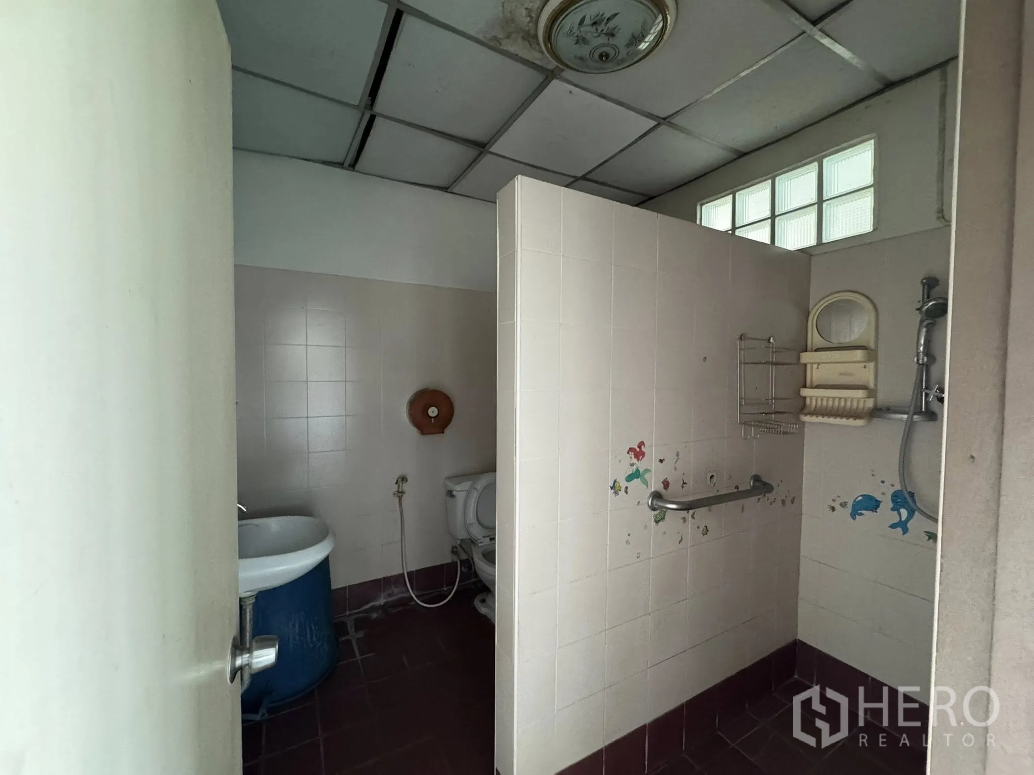 Warehouse for rent in Mueang Samut Sakhon, Samut Sakhon - Restroom with shower and grab bars, pink wall tiles and a makeshift sink.