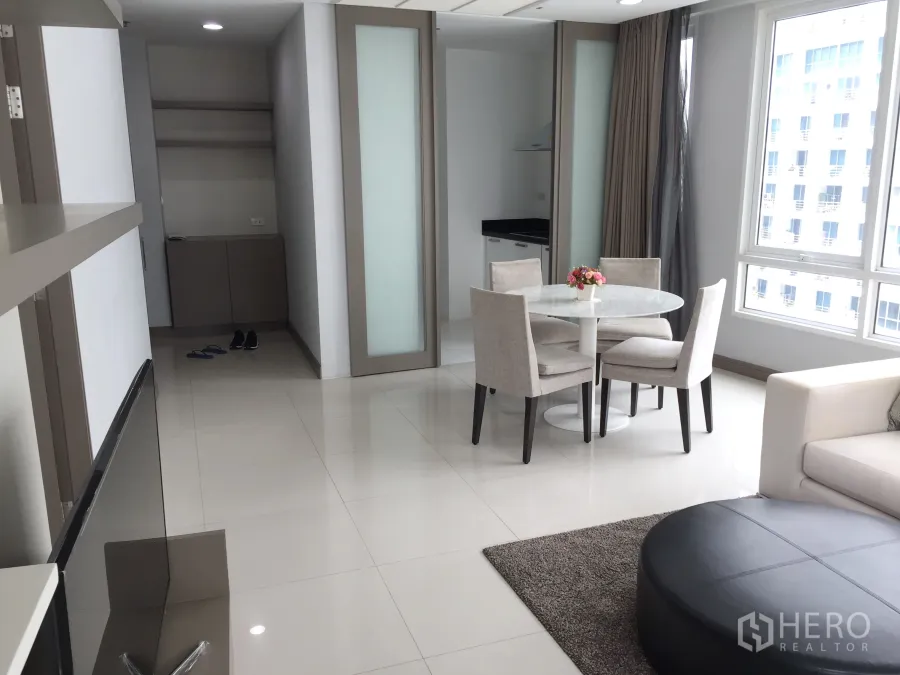 Condominium for rent in Pathum Wan, Bangkok - Bright living and dining area with round table, sofa and large windows in a modern Bangkok condo.