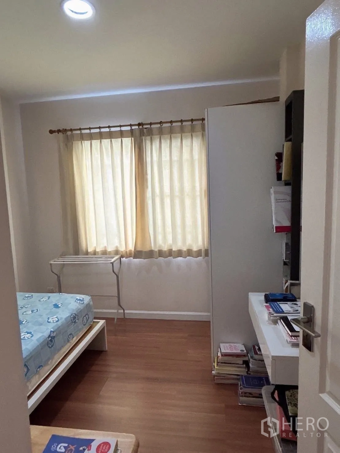 Detached House for sale in Bang Kapi, Bangkok - Small bedroom view toward the door with built-in desk and shelving.