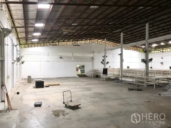 Warehouse for rent in Bang Kapi, Bangkok - Spacious warehouse interior with high steel truss roof, concrete floor and skylights.