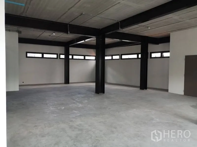 Office Space for rent in Chatuchak, Bangkok - Wide open office area with multiple beams and ample daylight from horizontal windows.