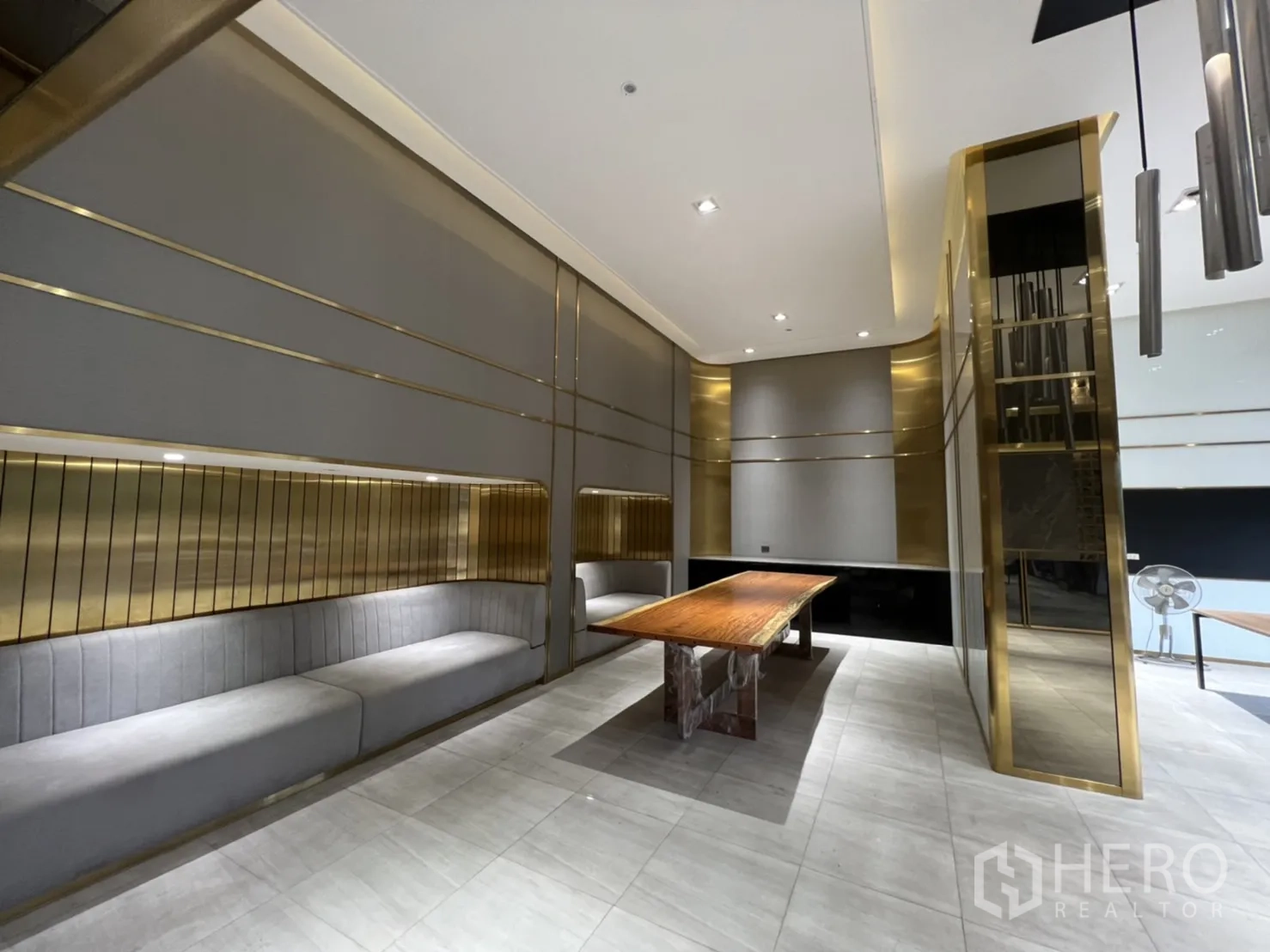 Shophouse for rent in Phra Khanong, Bangkok - Showroom lounge featuring built‑in upholstered seating, gold accents and high ceilings.