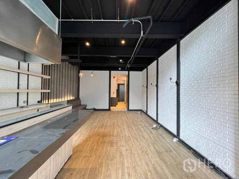 Shophouse for rent - Sales counter and shelving under a black ceiling in an industrial-style space.