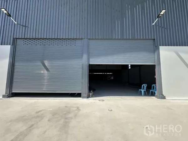 Warehouse for rent in Prawet, Bangkok - Close-up of dual roller shutter entrances leading into the warehouse loading bay.