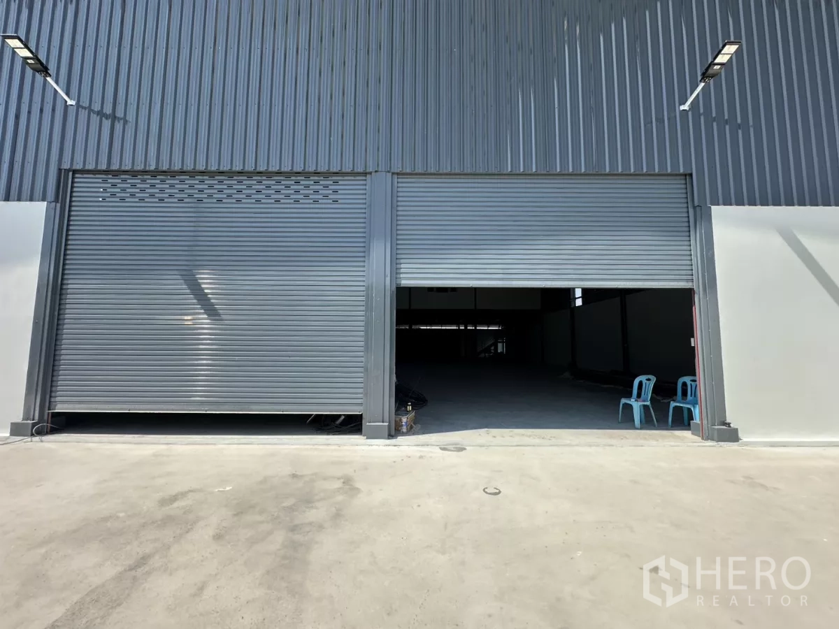 Warehouse for rent in Prawet, Bangkok - Close-up of dual roller shutter entrances leading into the warehouse loading bay.
