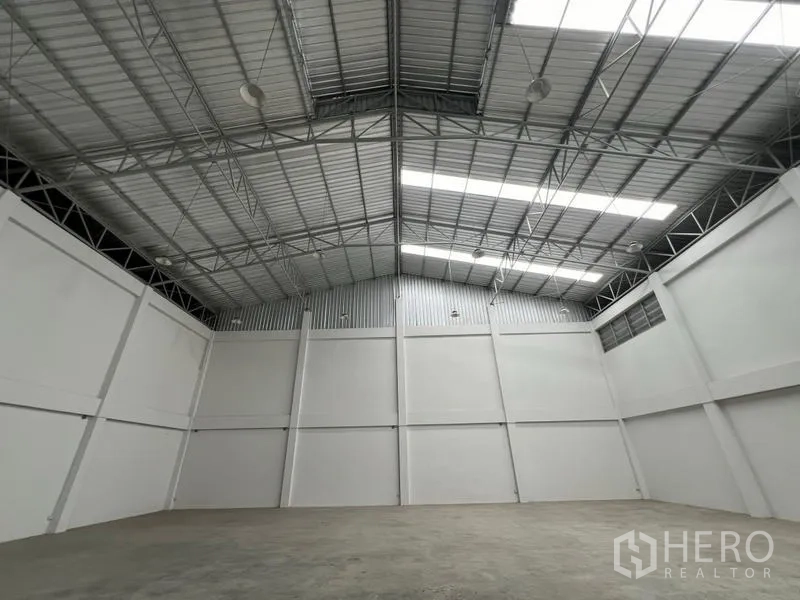 Factory for rent in Phra Samut Chedi, Samut Prakan - Clear-span manufacturing hall with insulated roof panels, skylight strips and smooth concrete slab.