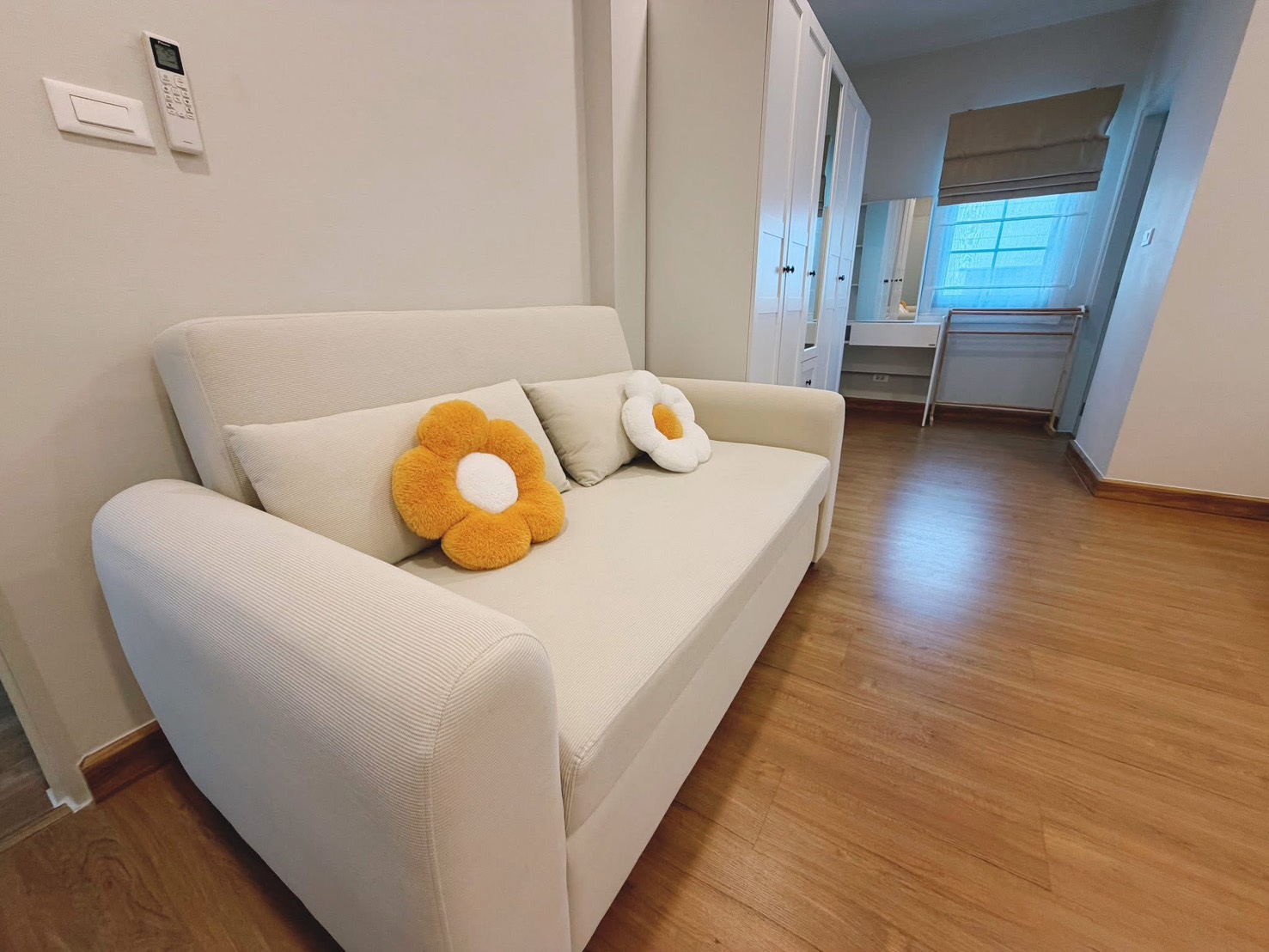 Detached House for rent in Bang Phli, Samut Prakan - Cozy sitting nook with beige loveseat and pillows beside wardrobes and window.