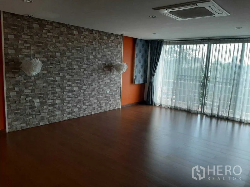 สำนักงานที่บ้าน ขายในPhra Khanong, Bangkok - พื้นที่นั่งเล่นโล่ง ผนังลายหิน พื้นไม้ และประตูกระจกบานเลื่อน