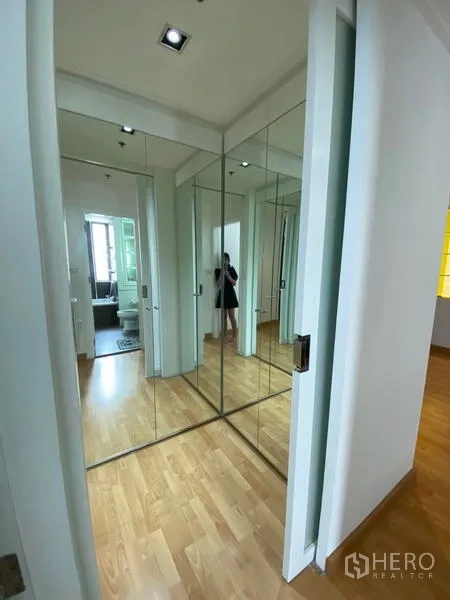 Condominium for rent in Khlong Toei, Bangkok - Hallway with mirrored wardrobes providing ample storage space.