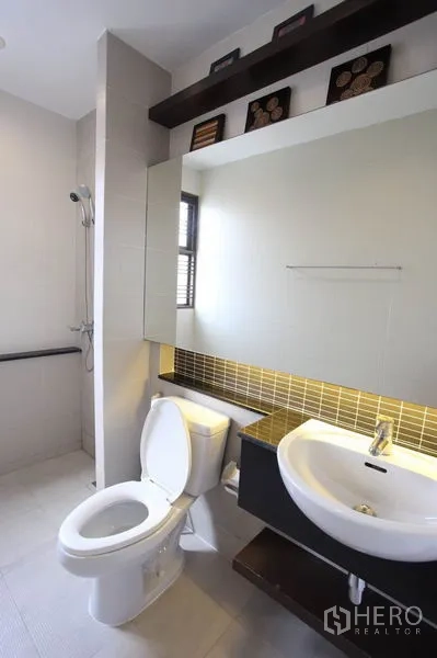 Townhouse for rent in Phra Khanong, Bangkok - Contemporary bathroom with large mirror, basin, toilet and walk-in shower.