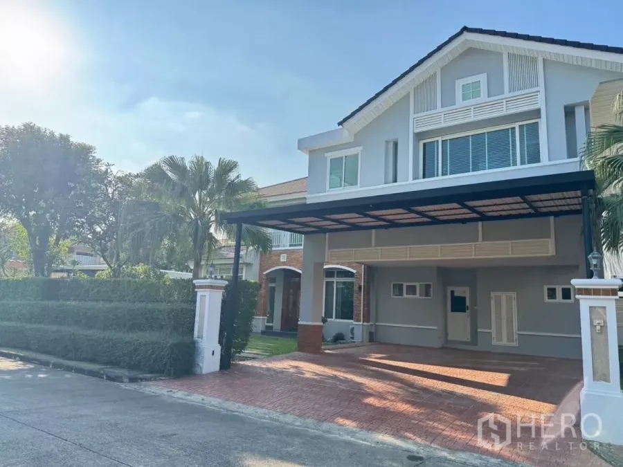 Detached House for rent or sale in Prawet, Bangkok - Two-storey detached house with covered carport, brick driveway and manicured hedges.