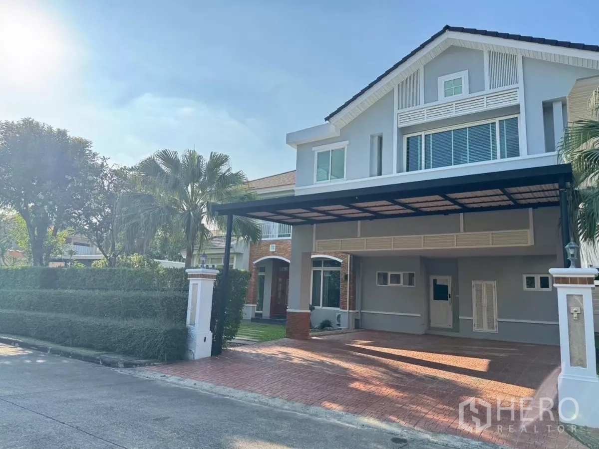 Detached House for rent or sale in Prawet, Bangkok - Two-storey detached house with covered carport, brick driveway and manicured hedges.