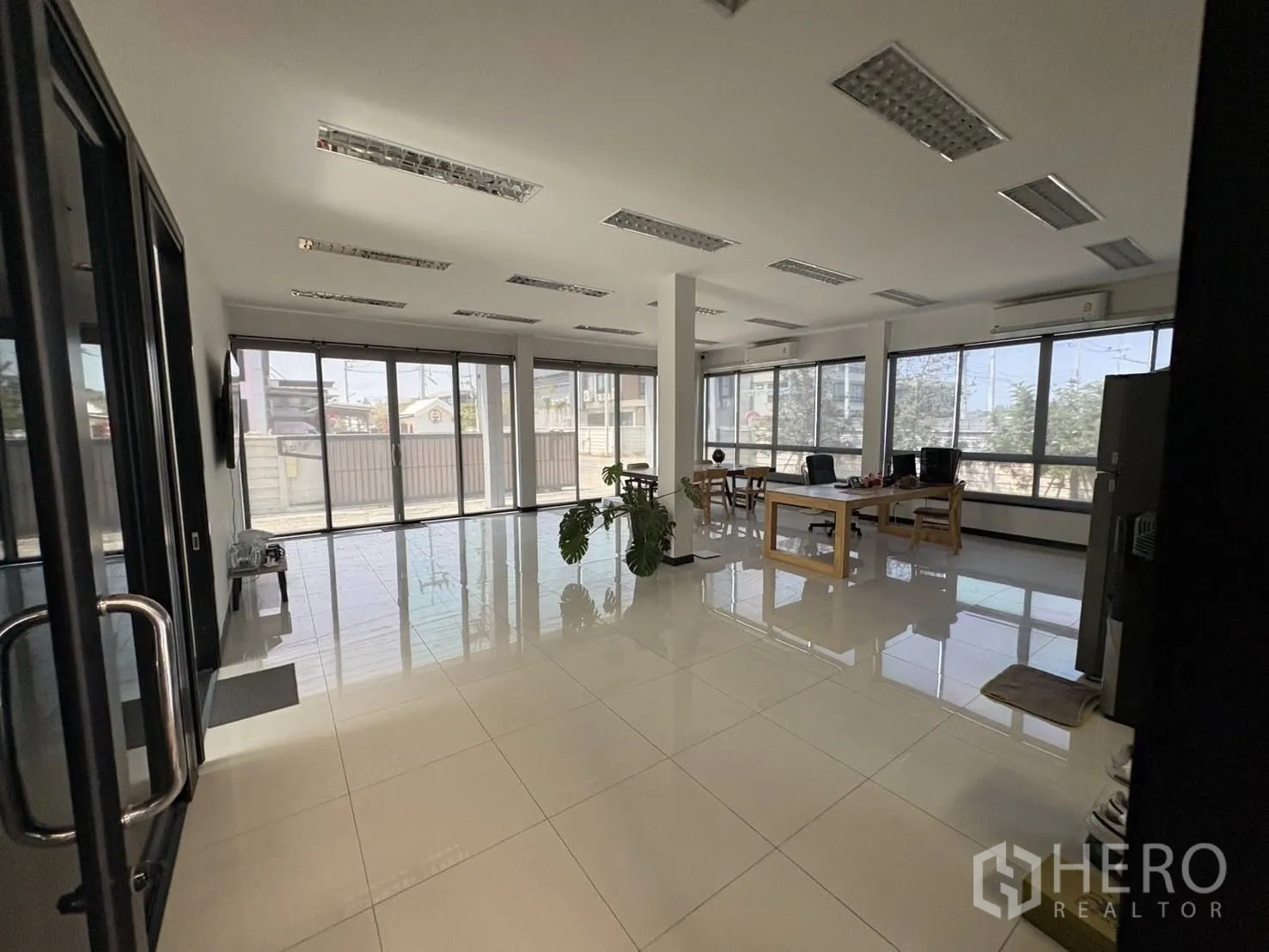 Factory for rent or sale in Bang Len, Nakhon Pathom - Bright office area with large windows, tiled floors, and work desks on the upper level.