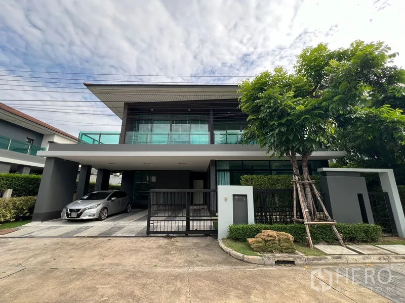 Detached House for rent in Bang Kapi, Bangkok - Modern two-storey detached house facade with gated carport and balcony.